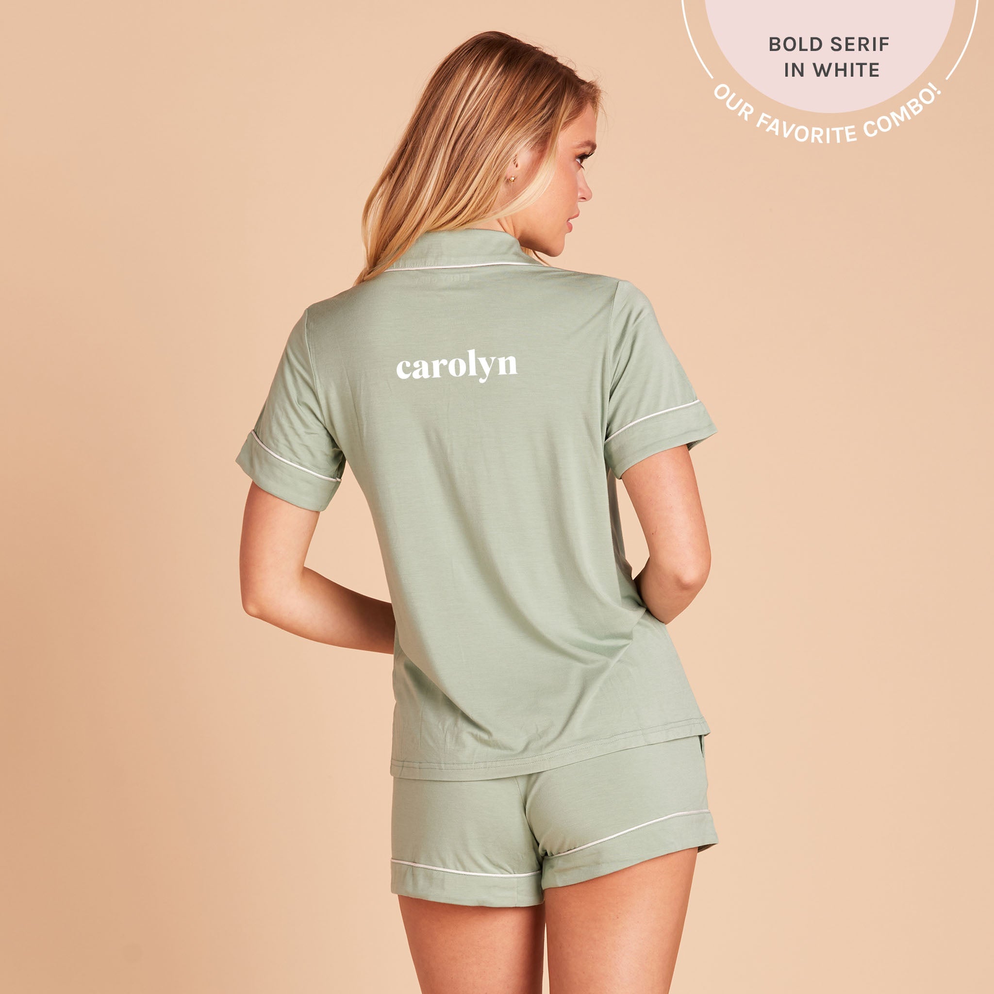 Back view of the Jonny Pajama Set in sage demonstrates the optional name personalization embroidered in the center of the pajama top, between the shoulder blades. The embroidery reads, “Carolyn,” in white, with a callout at the top of the photo that reads, “Bold serif in white. Our favorite combo!”