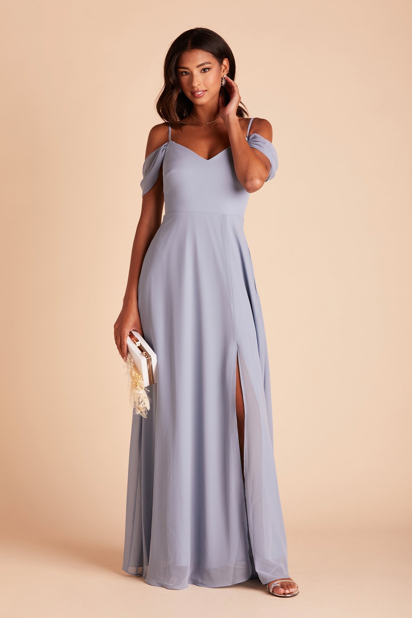 Front view of the floor-length Devin Convertible Bridesmaid Dress in dusty blue chiffon by Birdy Grey with a V-neck front and detachable sleeves. The flowing skirt features the optional slit over the front left leg.