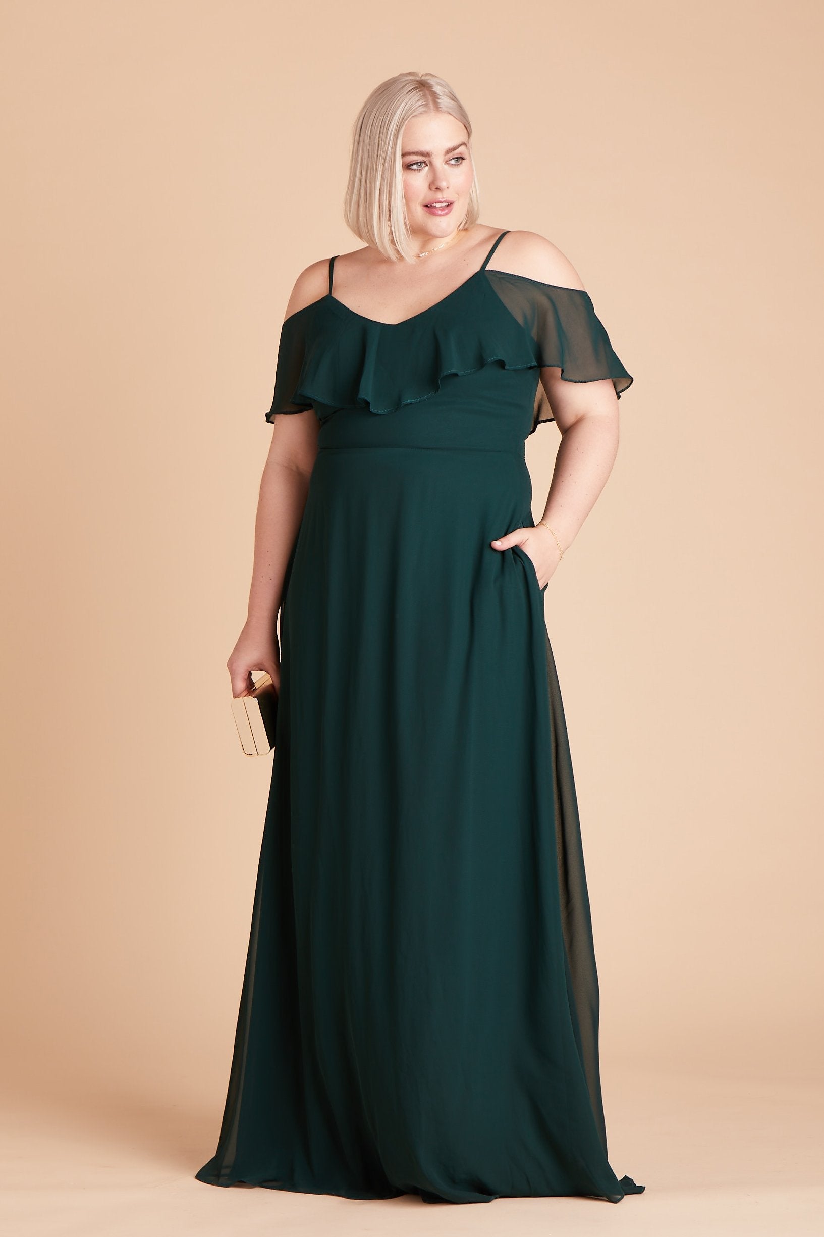 Jane convertible plus size bridesmaid dress in emerald green chiffon by Birdy Grey, front view with hand in pocket