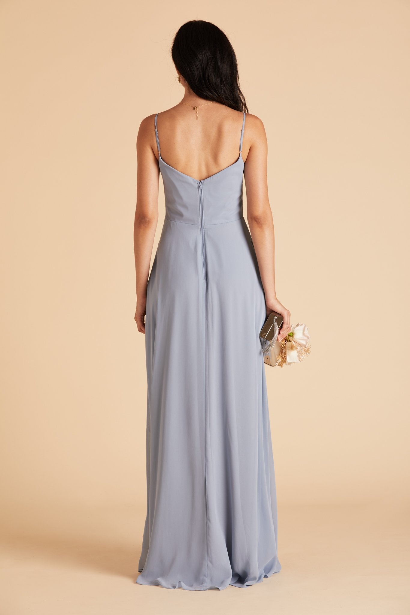 Back view of the floor-length Devin Convertible Bridesmaid Dress in dusty blue chiffon displays adjustable spaghetti straps and an open back with a slight v-cut just below the shoulder blades. 