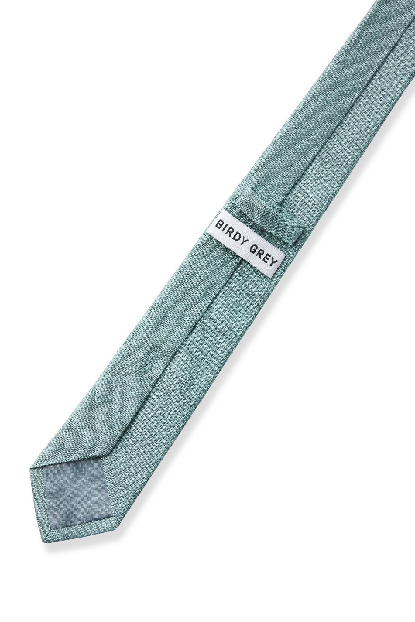 Elevated back view of the Simon Necktie in sea glass fully extended on a white background showing the necktie satin lining in medium grey, a keeper loop to tuck the necktie end, and a label that reads, 