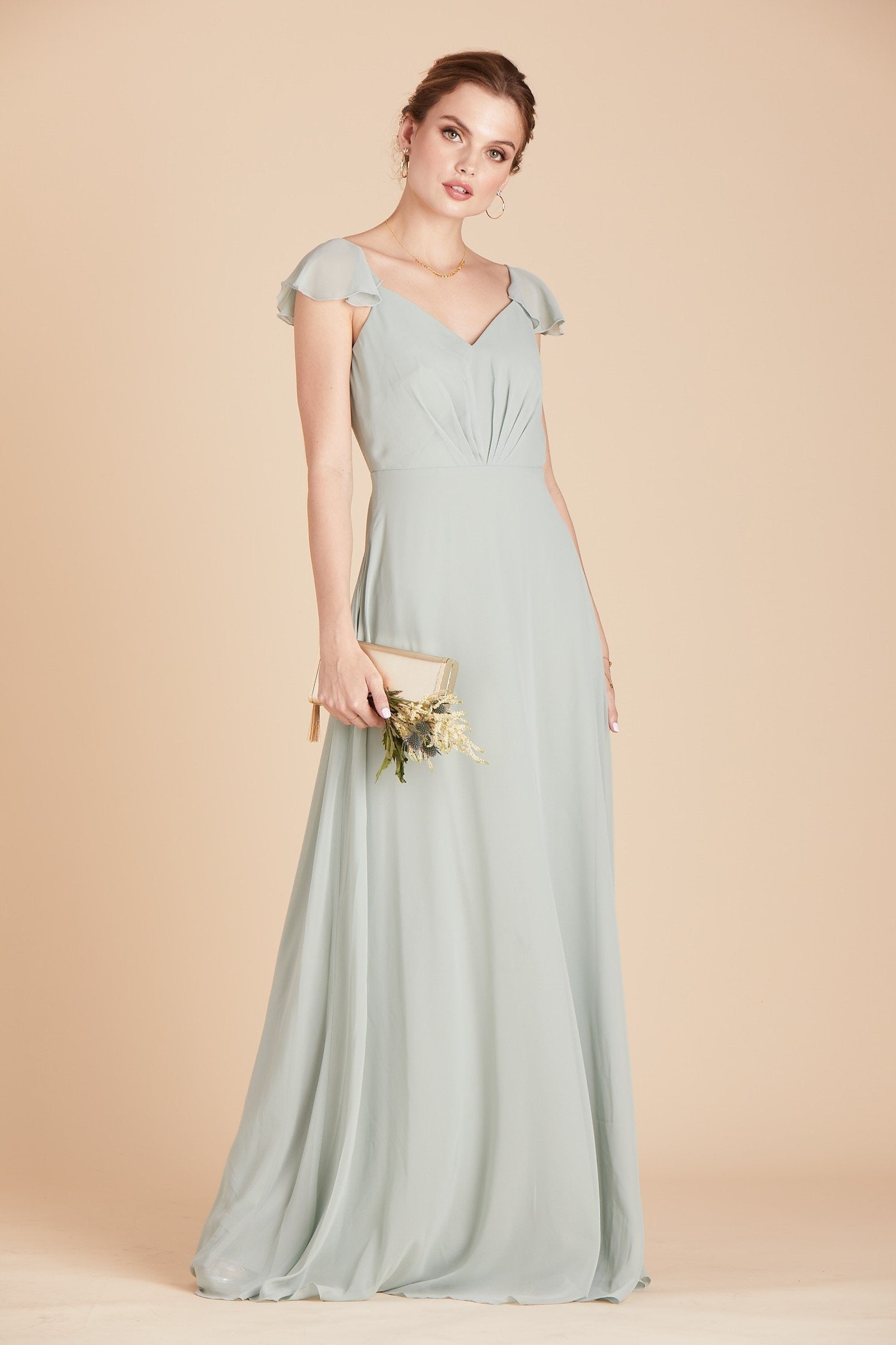 Front view of a floor length dress in sage chiffon worn by a slender model with a light skin tone. 