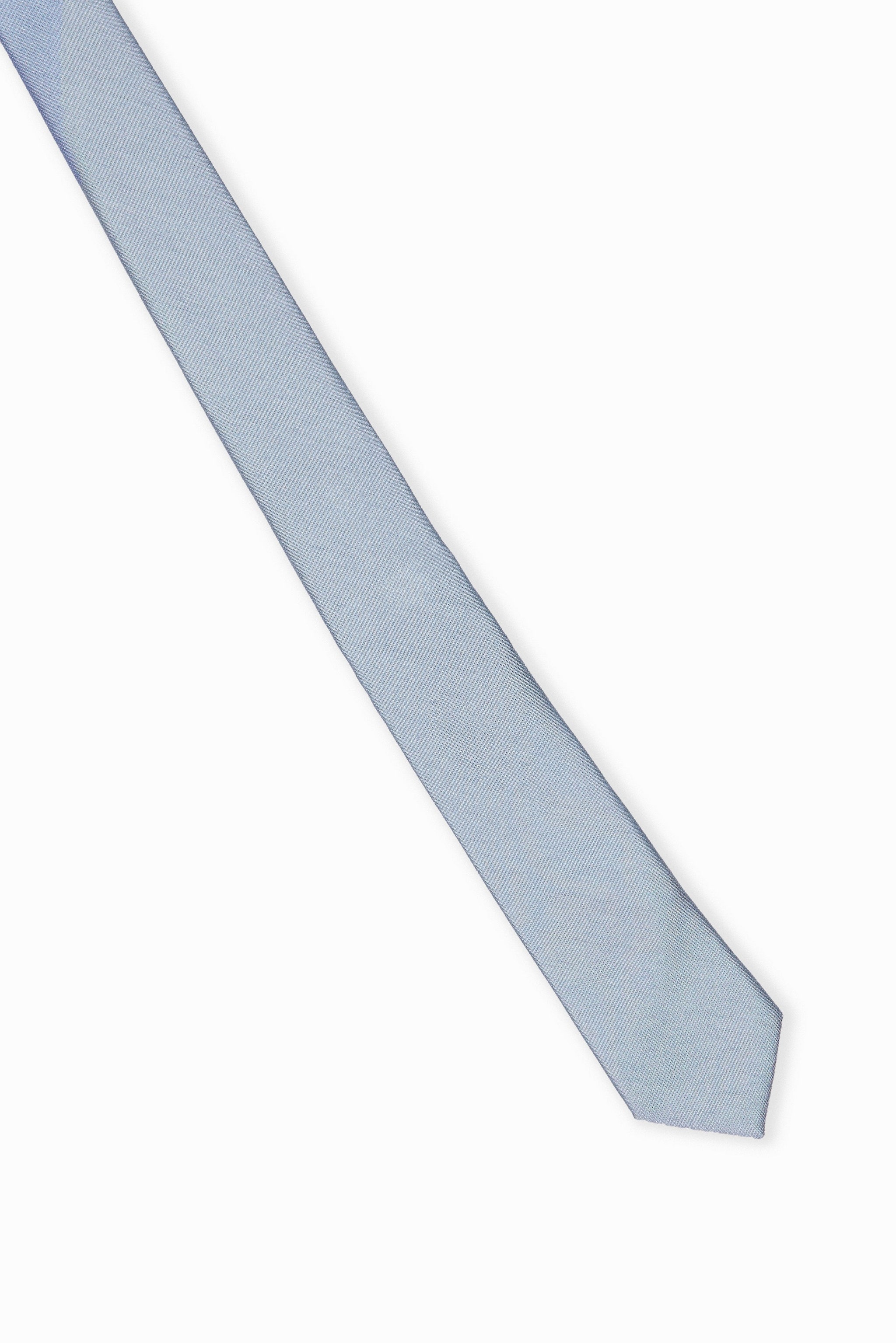 Elevated view of the Simon Necktie in dusty blue fully extended on a white background showing the width of the necktie.