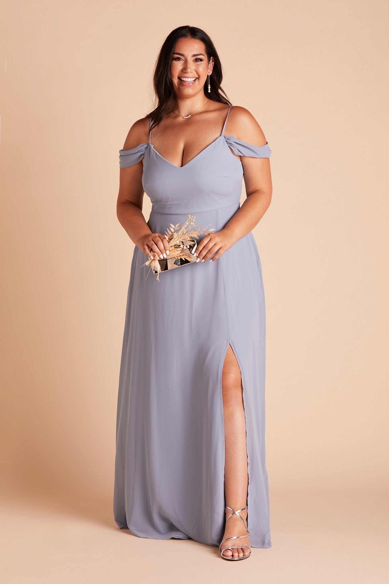 Front view of the floor-length Devin Convertible Plus Size Bridesmaid Dress in dusty blue chiffon by Birdy Grey with a V-neck front and draping detachable sleeves. The flowing skirt features a slit over the left leg.