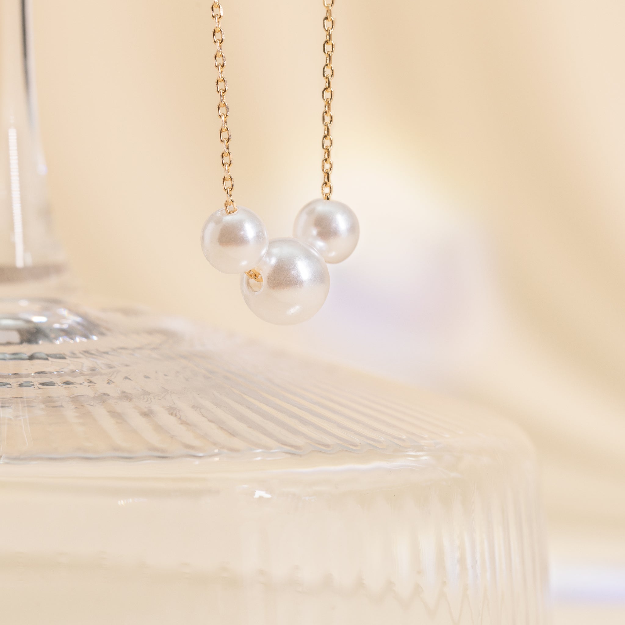 Close-up of the three pearls of the Durham Pearl Trio Necklace by Birdy Grey draping gracefully on a gold chain.