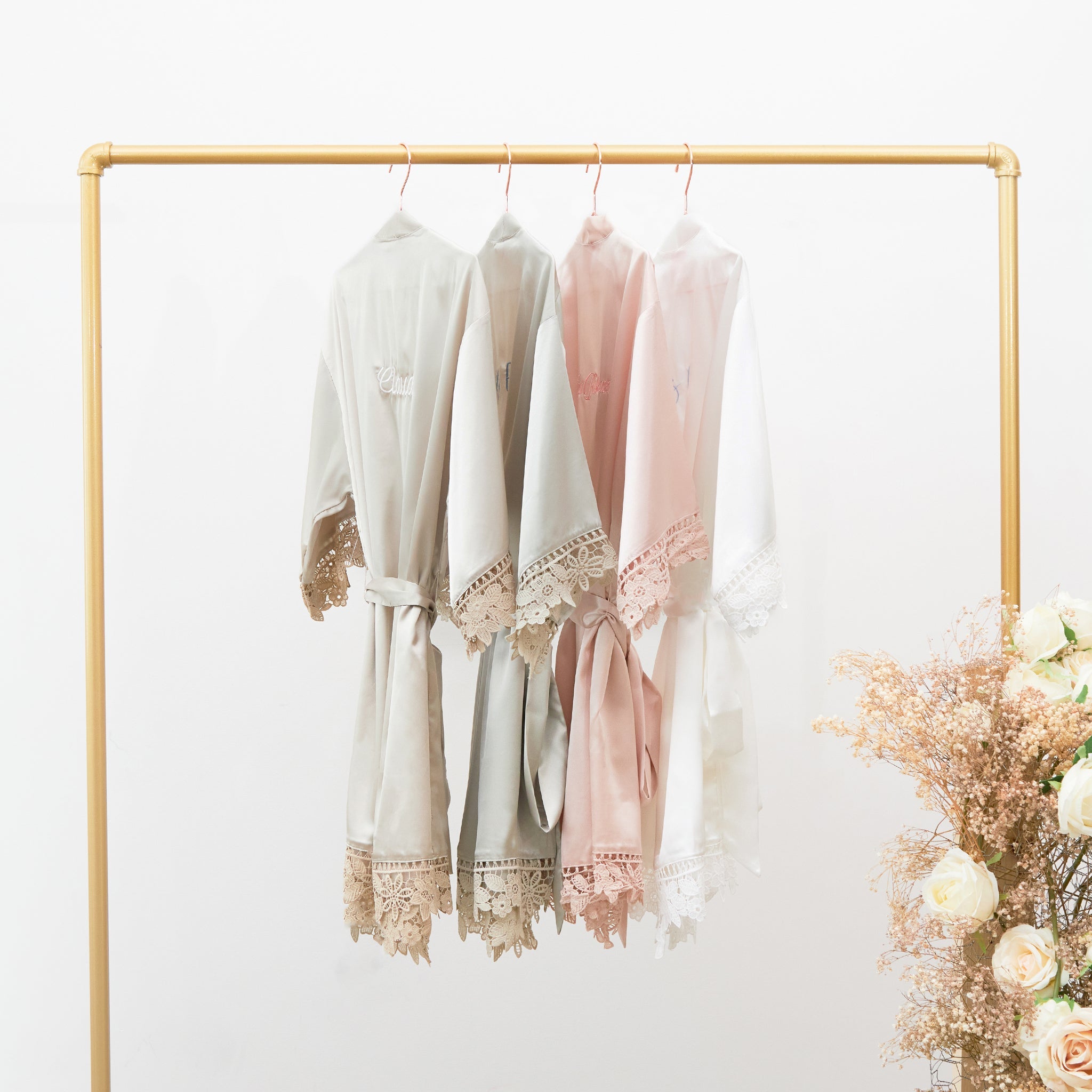 Almond Claudine satin lace robes on a rack