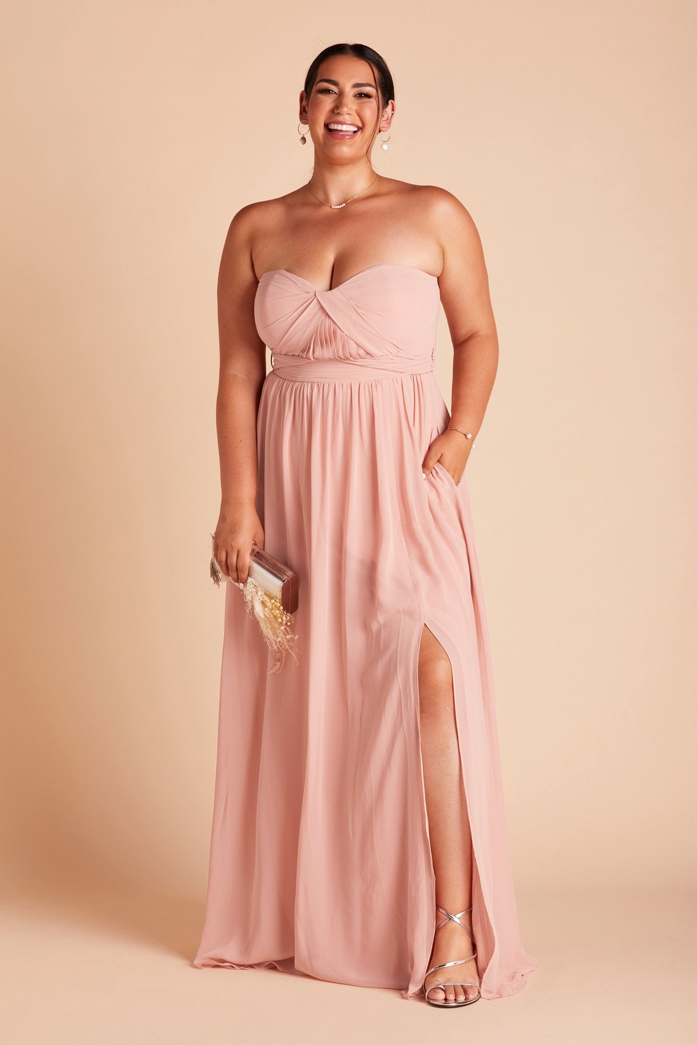 Grace convertible plus size bridesmaid dress with slit in rose quartz pink chiffon by Birdy Grey, front view with hand in pocket