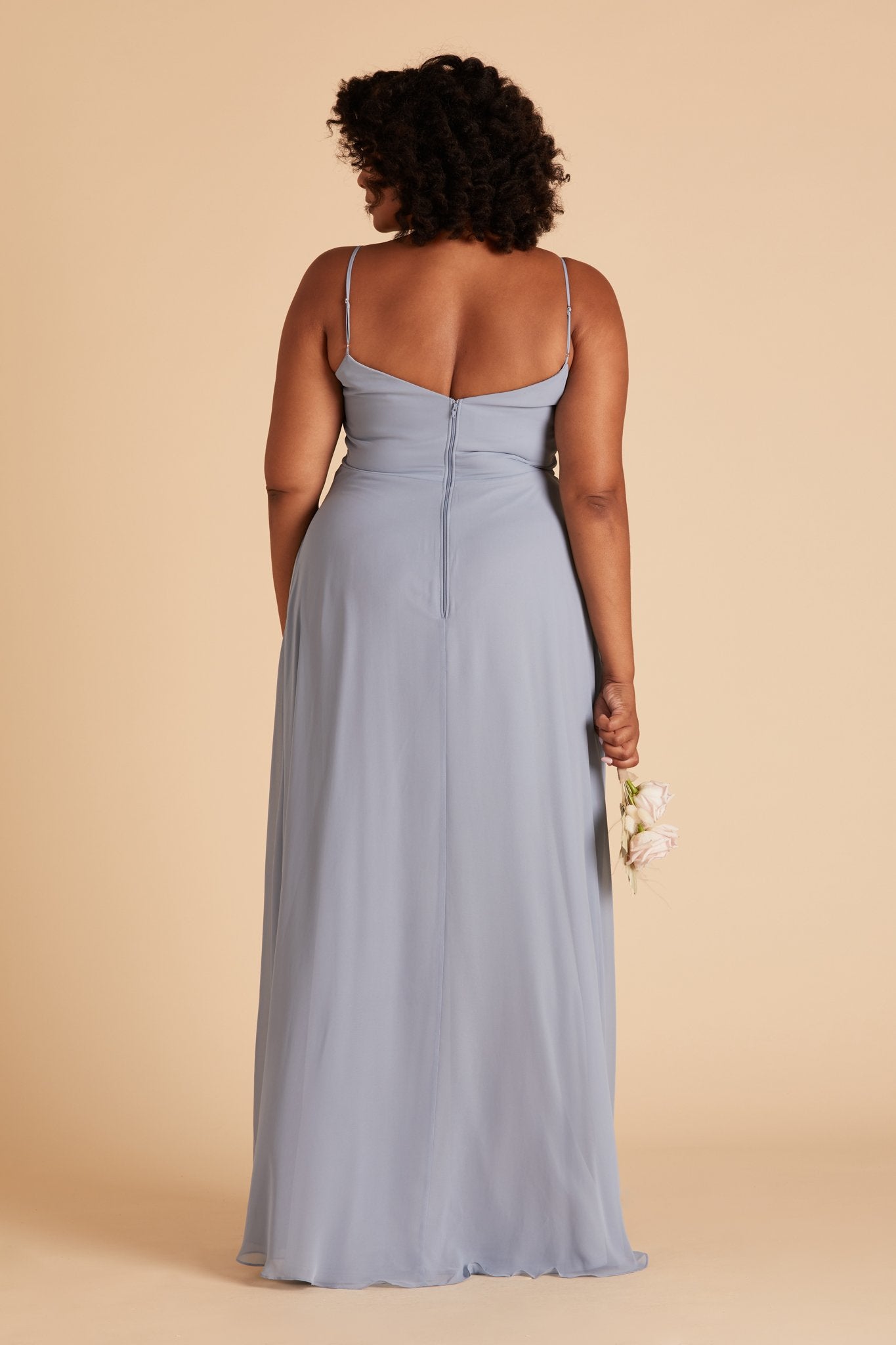 Back view of the floor-length Devin Convertible Plus Size Bridesmaid Dress in dusty blue chiffon displays adjustable spaghetti straps and an open back with a slight v-cut just below the shoulder blades.