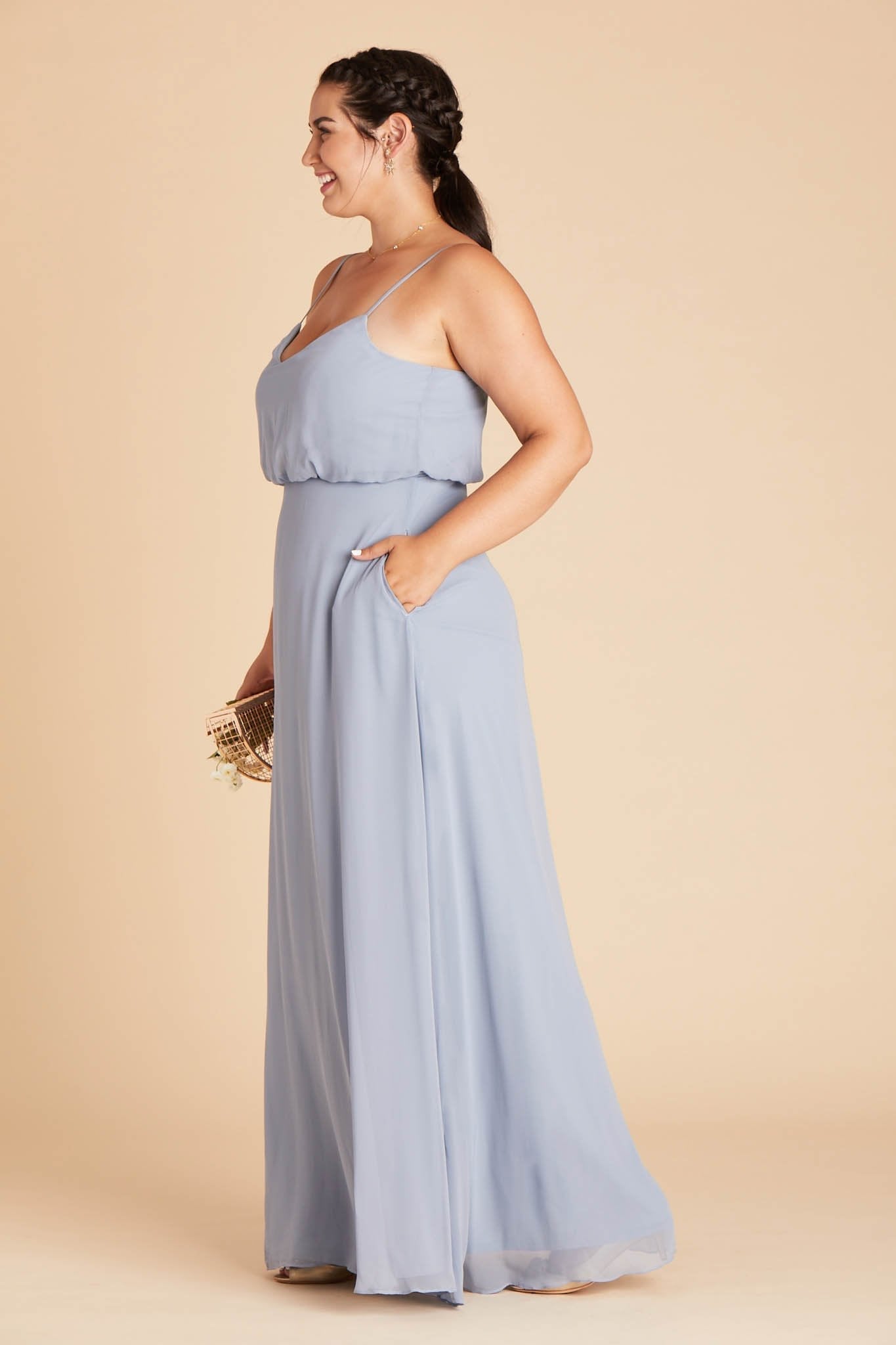 Gwennie plus size bridesmaid dress in dusty blue chiffon by Birdy Grey, side view with hand in pocket