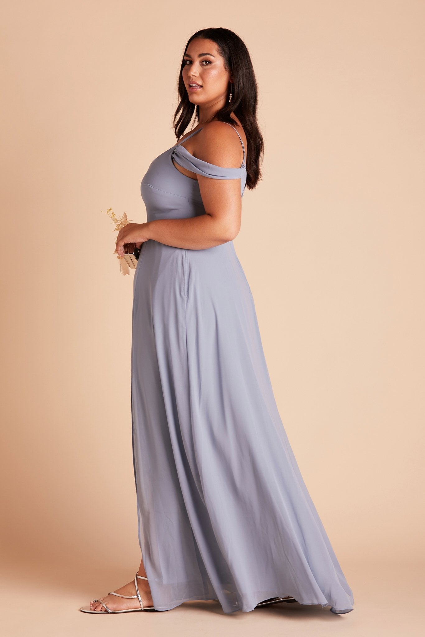 Side view of the floor-length Devin Convertible Plus Size Bridesmaid Dress in dusty blue chiffon reveals a fitted bust and flowing full-length skirt.