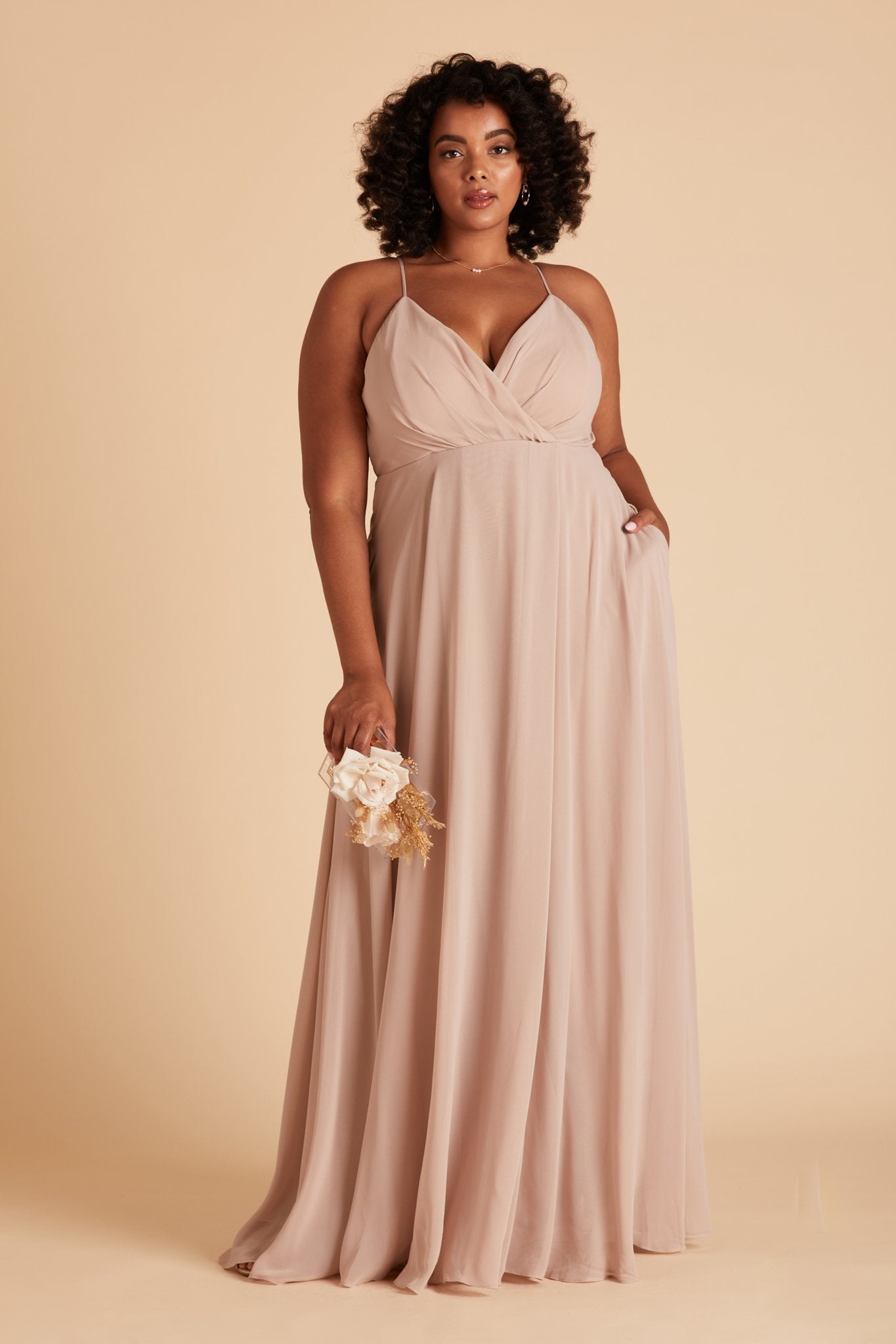 Kaia plus size bridesmaids dress in taupe chiffon by Birdy Grey, front view with hand in pocket