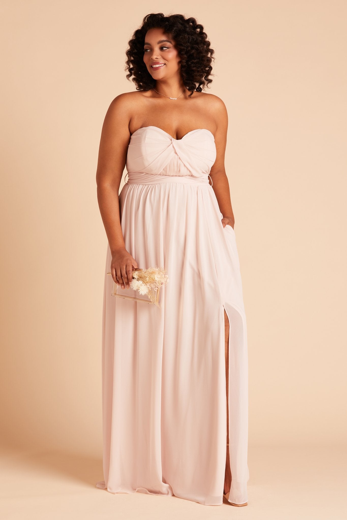 Grace convertible plus size bridesmaid dress in pale blush pink chiffon by Birdy Grey, front view with hand in pocket